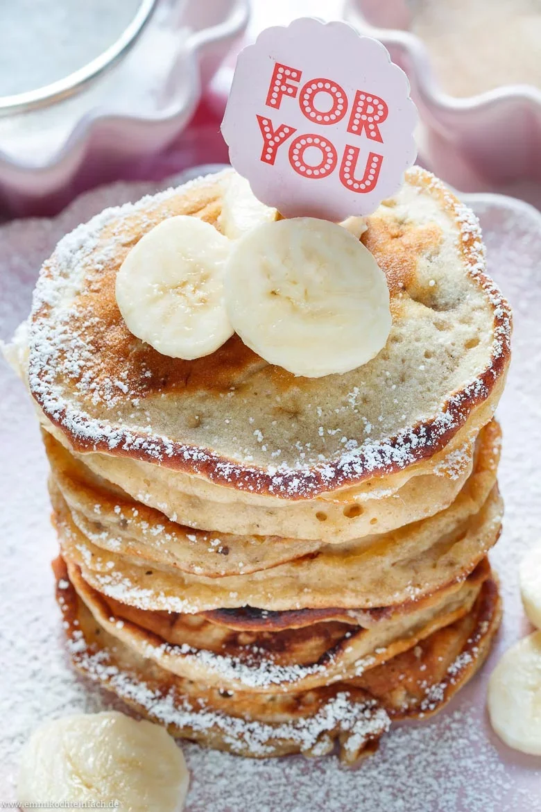 Klassische Bananen-Pancakes in Stapelform und bestäubt.