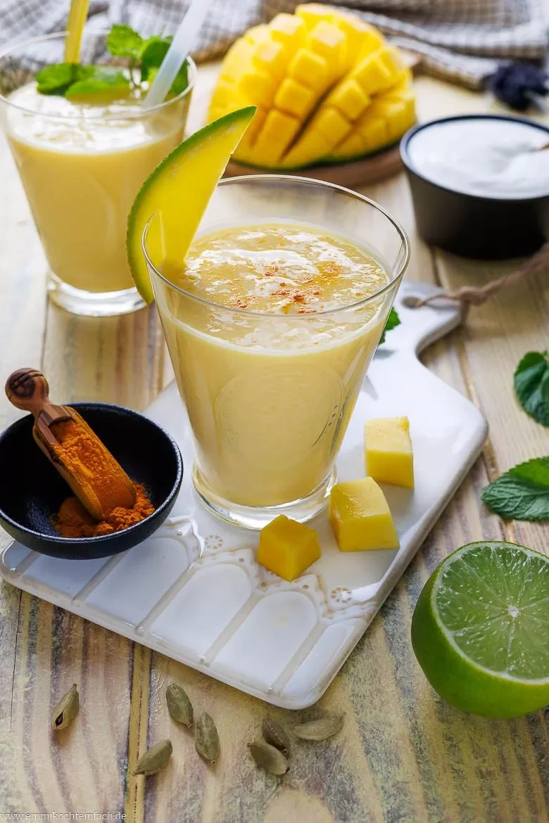 Mango Lassi garniert mit Mango-Spalten und Gewürzen